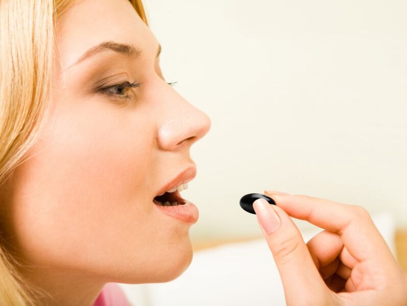 the girl takes a pill to prevent worms